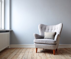 A simple room with a light gray armchair and a light beige throw pillow against a tranquil pale gray wall.
