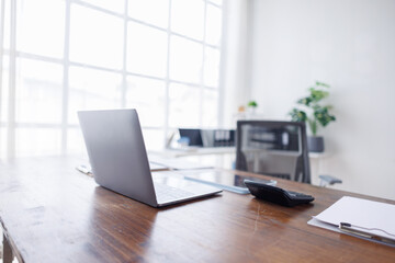 Open laptop computer on a wooden desk in a office room at home 
