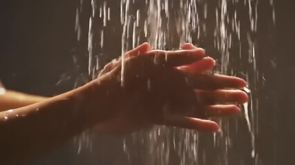 Womans hands under shower stream.