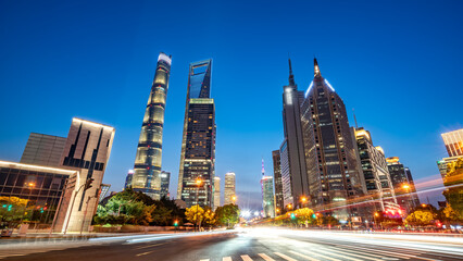 Fototapeta premium City skyline at dusk with modern skyscrapers and light trails