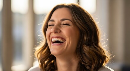 A candid close-up of a joyful woman laughing heartily with her eyes closed, bathed in warm sunlight, expressing genuine happiness and positive emotion.