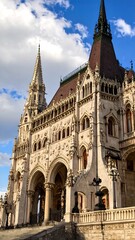 Fototapeta premium A grand gothic style building with intricate details and tall spires against a vibrant sky.