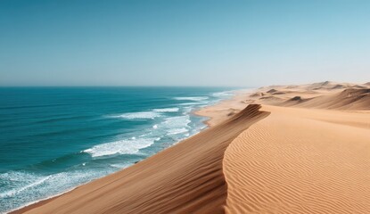 Desert dune meets turquoise ocean.  Vast landscape, waves crash on shore