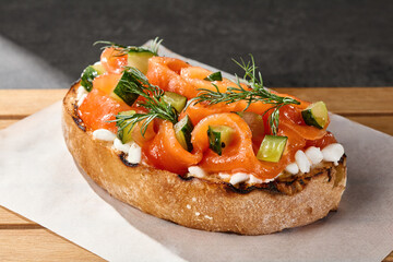 Salmon bruschetta with creamy cheese and cucumber, bright rustic lighting, overhead composition