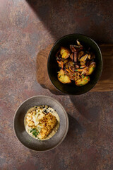 Cauliflower steak on creamy sauce, rustic moody overhead, with fried potatoes and chanterelles companion
