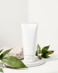 A white cosmetic tube with a minimalistic design on a stone and leaves.