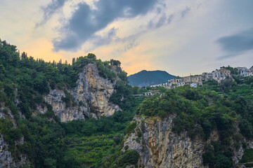 Naklejka premium Coastal Cliffside Village, Cloudy Sky, Mediterranean Landscape