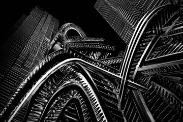 Low-angle shot of a complex metal structure against skyscrapers