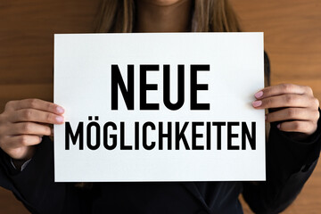 Neue Möglichkeiten (New opportunities) Woman holds a white page. Chance, aspirations, success, reminder, business strategy, direction.