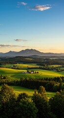 Rolling green hills and farmland at sunset with distant mountains