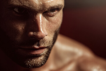 Obraz premium closeup portrait of man with focused expression sweat on his temples and confident gaze