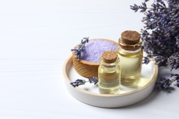 Bottles of herbal lavender oil on gray background