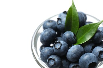 Raw organic blueberries in a glass bowl, side view.