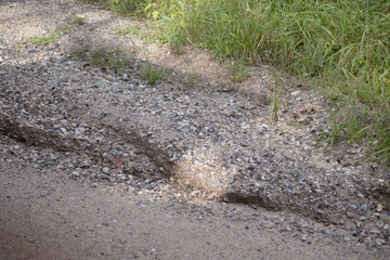 A rut eroded into the gravel road