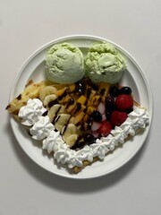 Delicious ice cream-filled crepes, drizzled with chocolate sauce and topped with fresh fruits. Perfect for dessert photography, showcasing the delightful combination of flavors and texture