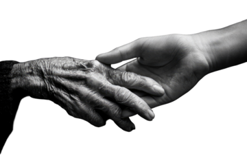 Close-up of two hands clasped.  A weathered hand of an elderly person meets the younger hand.  Care and support are shown