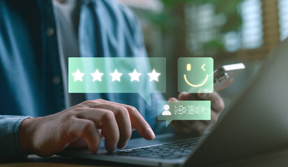 Close-up of hands using laptop and smartphone, with floating five-star rating and feedback icons. Concept of online review, customer satisfaction, service rating and digital user experience.
