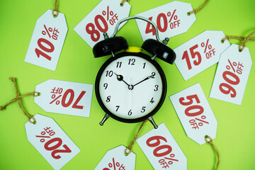 Clock surrounded by various discount tags with percentages like 10%, 20%, 30%, up to 90% off, set...