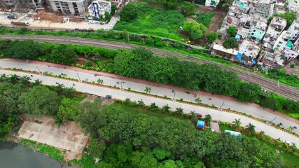 Buildings with PVNR Marg, greenery and Railway Track near Hussain sagar lake, hyderabad. day time, push in, tilt down, drone shot, 4k.