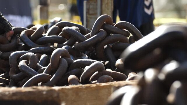 Slow motion footage of athletes grabbing heavy rusty industrial chains during intense workout training with dramatic lighting and powerful movements