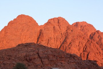 Sunset illuminates reddish-brown rocky mountains