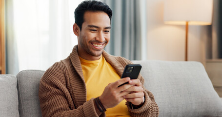 Phone, reading and smile with man on sofa in living room of home for social media scrolling. App, communication and information with happy person in apartment for internet search or text message