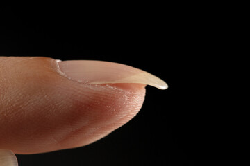 Clean normal long fingernail without color or coating on nail. Long clean fingernail to show texture detail of uneven nail and scratch skin, black background isolated