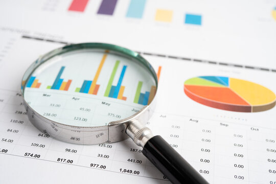 Magnifying glass on spreadsheet and graph paper. Financial data economy, Business.