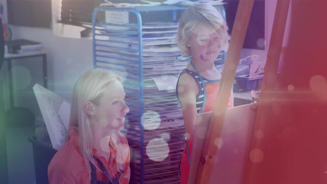 Animation of lights over caucasian teacher and caucaisan school girl at art class