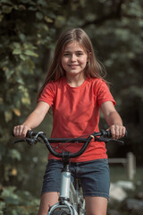 Naklejka premium Young girl learning to ride a bike