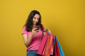 Young woman holding shopping bags and credit card