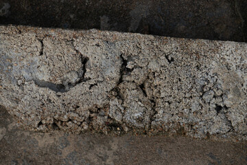 Macro texture of the very rough and gritty edge of a broken concrete slab. An industrial grunge background for design