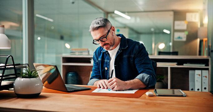 Writing, laptop and documents with business man in office for budget research, planning or graph. Profit chart, account review and paperwork with mature person for finance, revenue balance and growth - Powered by Adobe