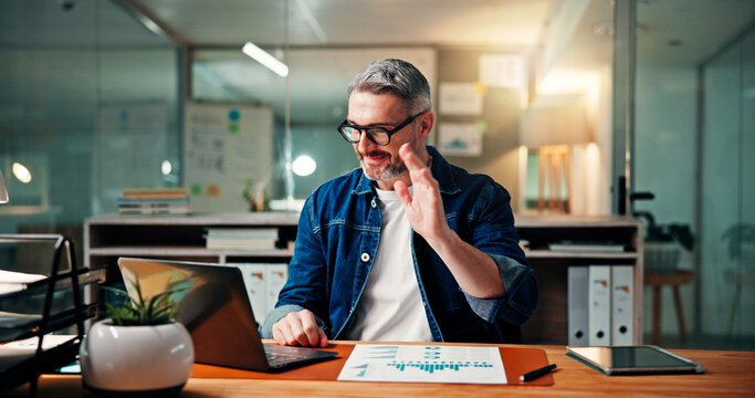 Mature, happy man and night with wave on laptop for video call or online meeting in office. Male person, financial advisor or working late with statistics, documents or hello for webinar in workplace - Powered by Adobe