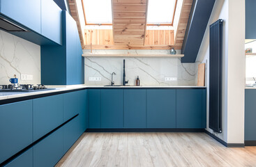 Corner attic kitchen. Scandinavian blue design. Matte cabinetry.