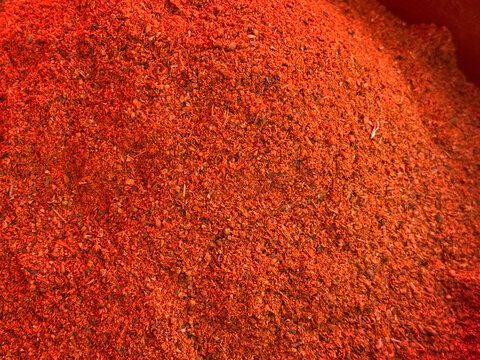 Close-up of bright red spice mixture with seeds and herbs. Culinary ingredients, flavor diversity and gastronomy.