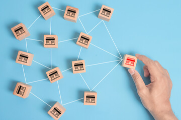 Distribution franchise branch store. Hand placing red franchising shop cube wooden block business...