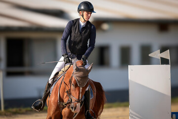 Close-up portraits of a show jumper jumping over an obstacle in a competition.