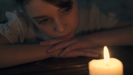 Sad little girl with a candle