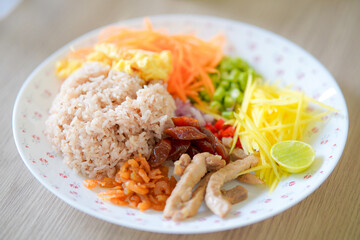 Khao Kluk Kapi is a traditional Thai dish made by stir-frying rice with shrimp paste. It has a strong, salty flavor and is usually served with a variety of side toppings such as sweet pork