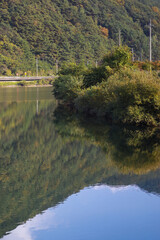 The mountain forest is reflected in the clear blue lake