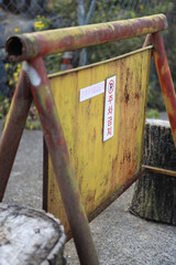 Korean signs are posted on rusty yellow metal plates: "No parking," "No entry except by authorized personnel."
