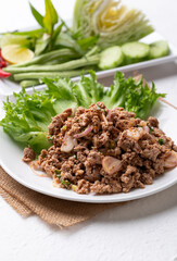 Local Thai food, Spicy minced pork salad (Larb Moo) eating with fresh vegetables on white background
