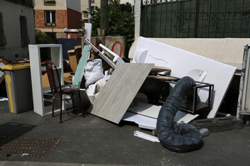 Dépôt sauvage dans la rue de planches et de détritus divers
