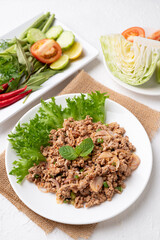 Local Thai food, Spicy minced pork salad (Larb Moo) eating with fresh vegetables on white background