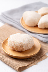 Lion's Mane mushroom or Yamabushitake mushroom on wooden plate