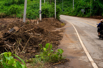 Motorcycle Riding on Flood-Damaged Rural Road with Mud and Debris