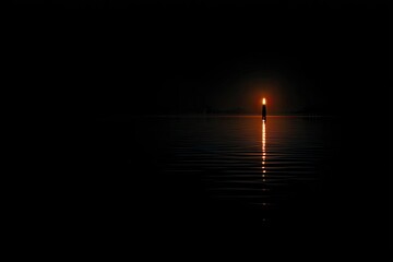 Single candle flame, reflected in still water, dark night