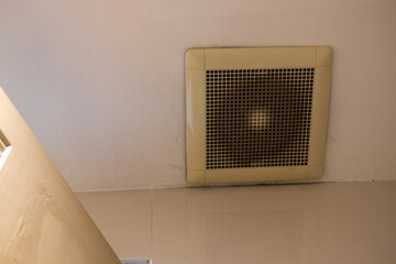 Dirty bathroom ceiling exhaust fan covered in dust showing poor ventilation and maintenance need