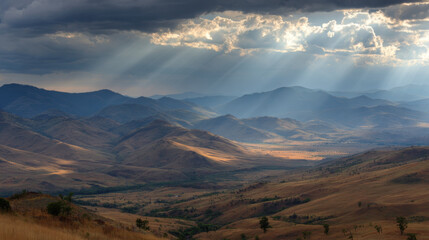 Majestic mountain landscape with rolling hills and valleys under dramatic sky. Sunlight breaks through clouds, casting rays over terrain, creating serene and breathtaking view